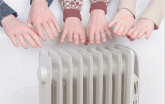Three people warming their hands over a heater