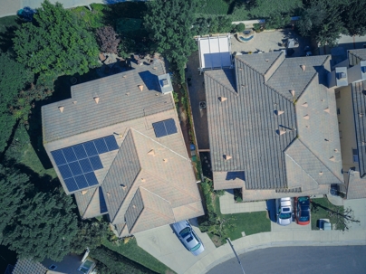 aerial view of houses with and without solar panels