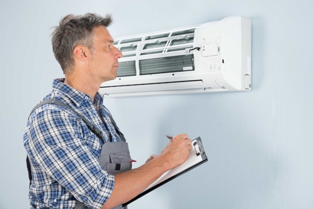 man inspecting AC